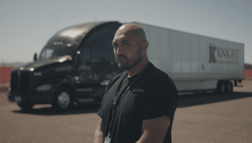 Owner Operator Truck Driver standing in front of a Knight Transportation truck