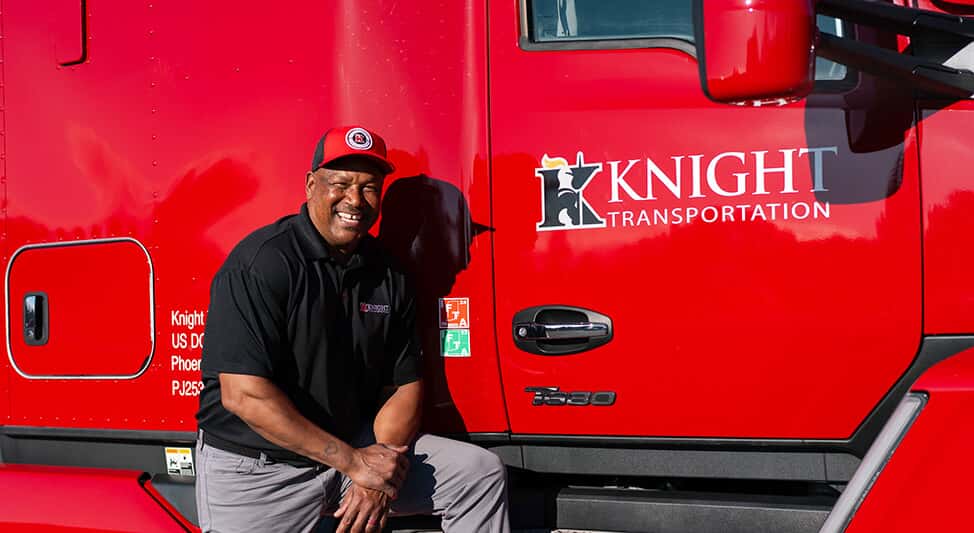 Veteran truck driver for Knight Transportation standing next to their truck